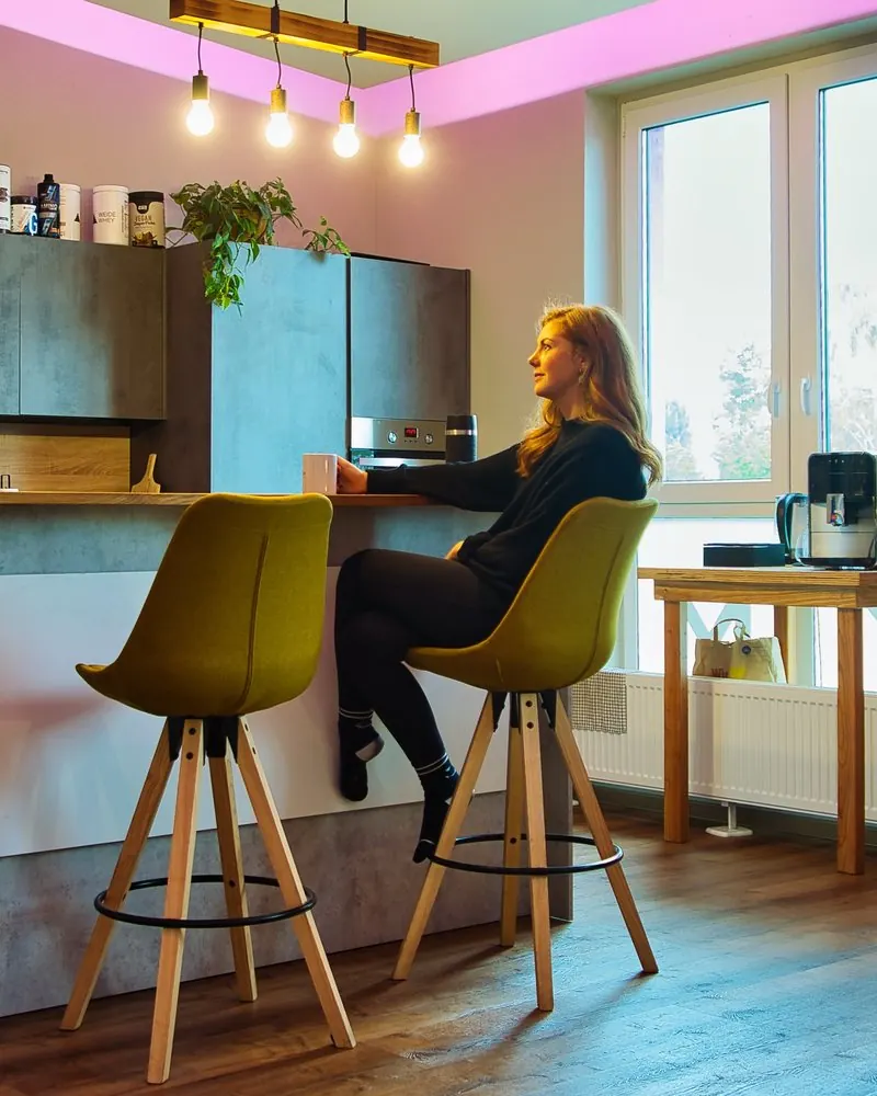 Mitarbeiterin mit Kaffeetasse an der Theke einer Teamküche